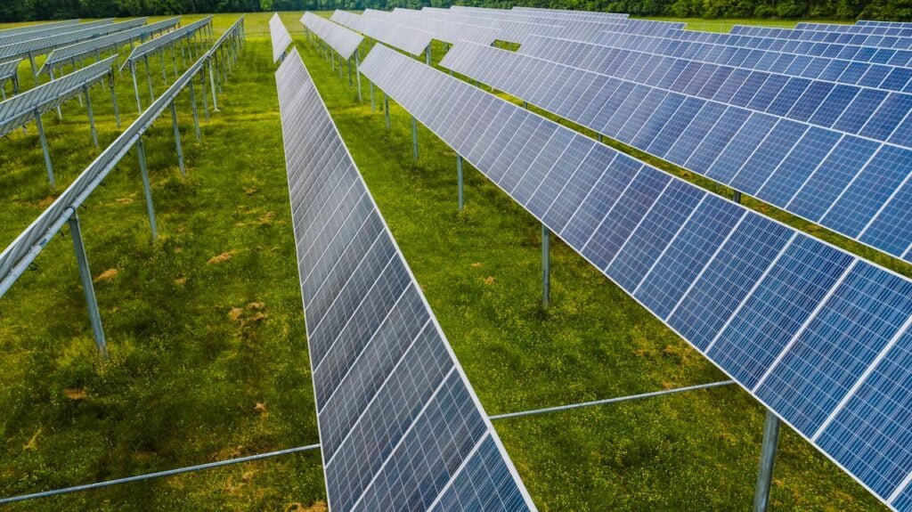 Solar modules on green field in photovoltaic station